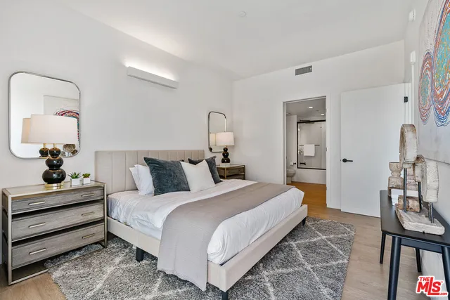 a bedroom with bed cabinet and mirror