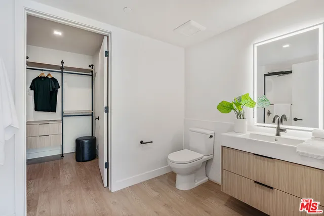 a bathroom with a granite countertop sink toilet and mirror