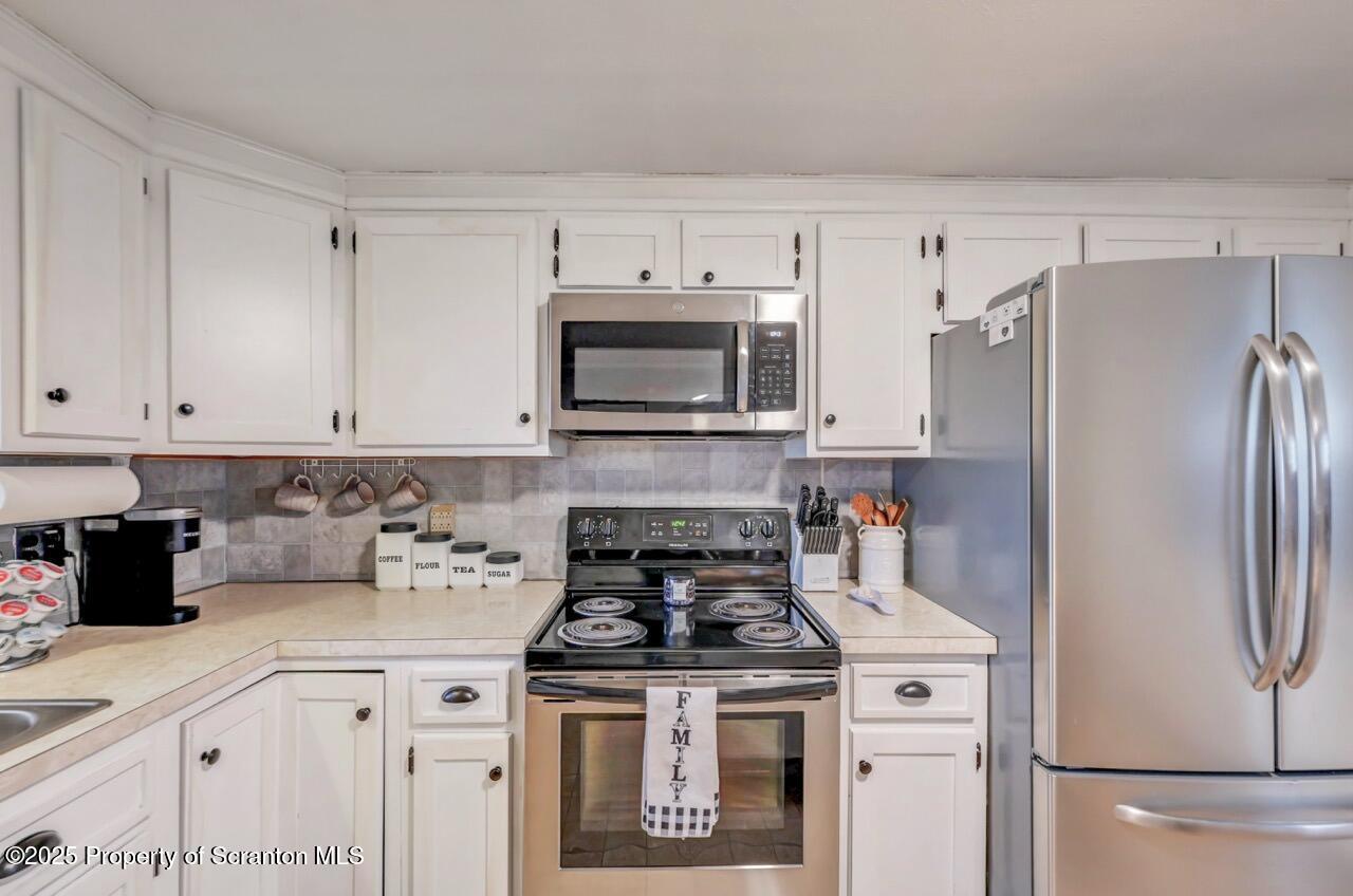 167 Handley Street Eynon, PA 18403 - Photo 19 of 48 a kitchen with refrigerator a stove a microwave and cabinets