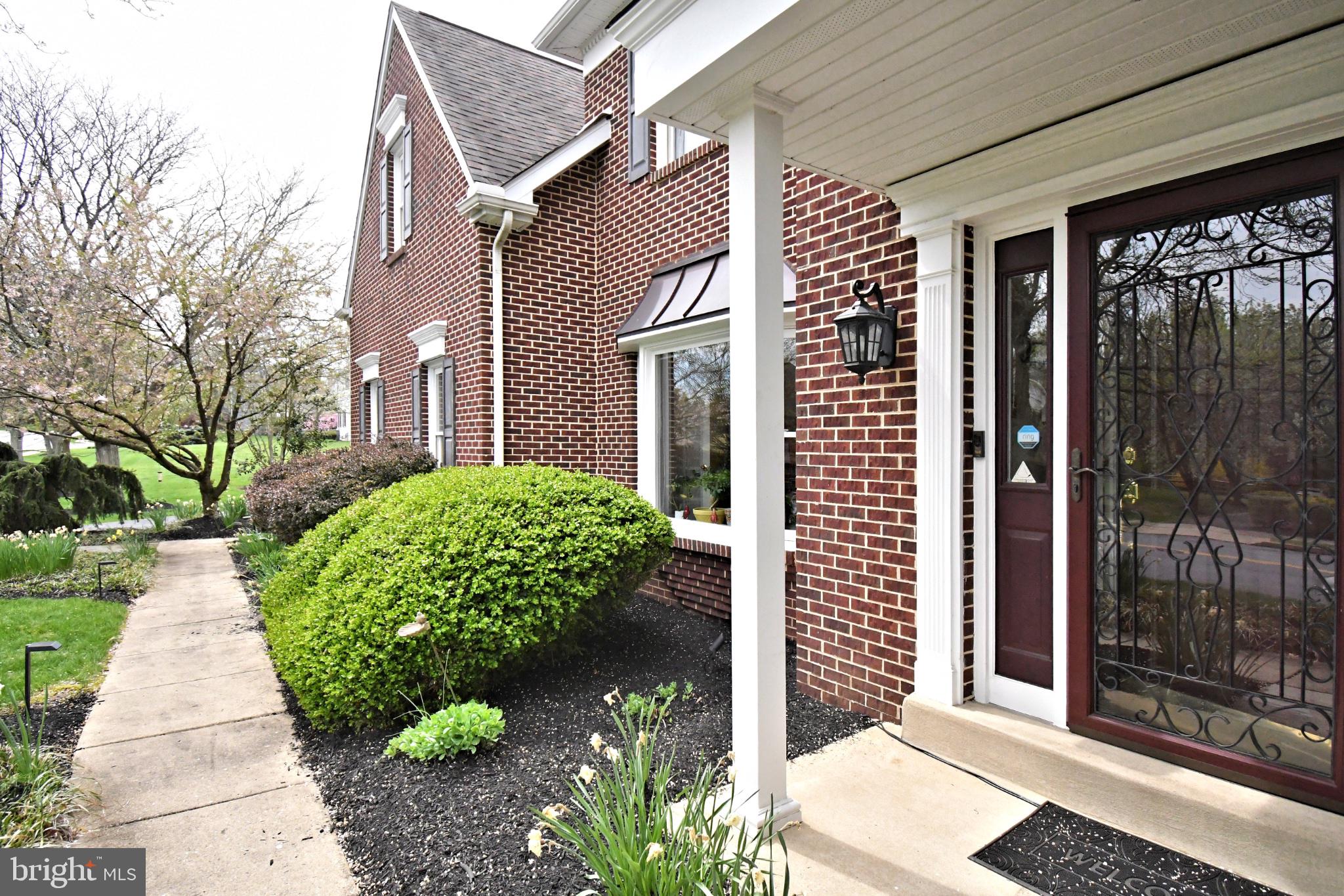 112 South Mennonite Road Collegeville, PA 19426 - Photo 6 of 131 Charming brick facade with lush greenery.