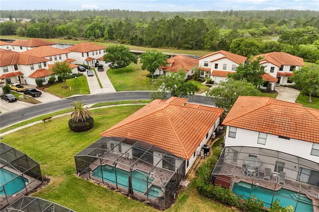 an aerial view of residential houses with outdoor space and swimming pool