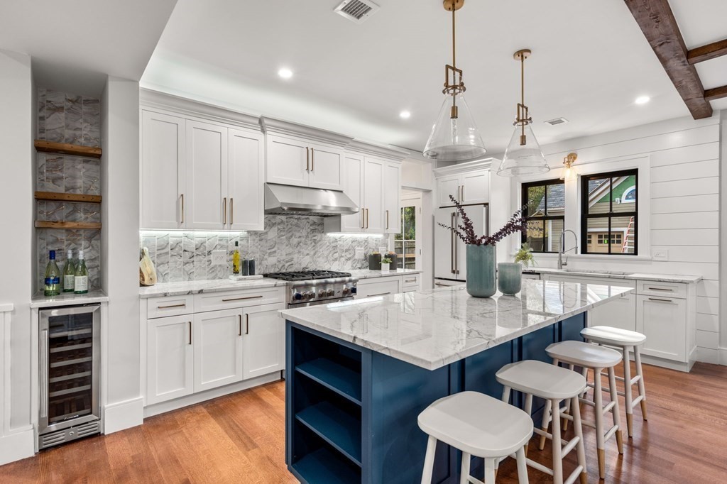 300 Elliot Street, Unit 2 Newton, MA 02464 - Photo 2 of 16 a kitchen with granite countertop a stove a sink dishwasher a dining table and chairs with wooden floor