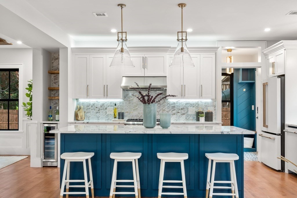 300 Elliot Street, Unit 2 Newton, MA 02464 - Photo 3 of 16 a kitchen with stainless steel appliances kitchen island granite countertop a table and chairs in it