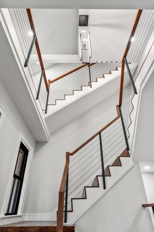 300 Elliot Street, Unit 2 Newton, MA 02464 - Photo 10 of 16 a view of staircase with lots of frames on wall and a window