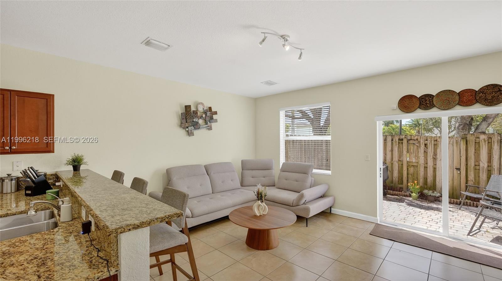9041 Southwest 227th Street, Unit 5 Cutler Bay, FL 33190 - Photo 12 of 41 a living room with furniture and a chandelier