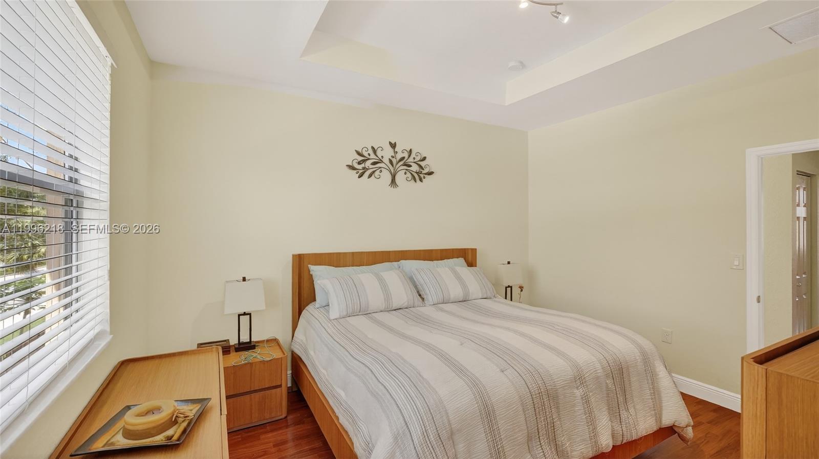 9041 Southwest 227th Street, Unit 5 Cutler Bay, FL 33190 - Photo 16 of 41 a bedroom with a bed and wooden floor