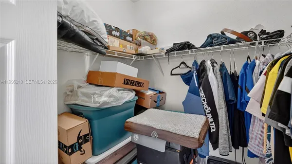 a view of walk in closet with clothes and shoes