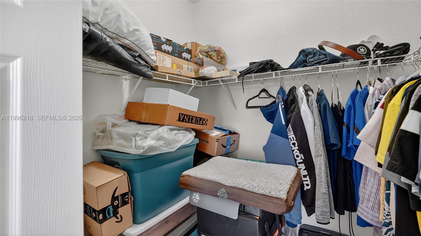 9041 Southwest 227th Street, Unit 5 Cutler Bay, FL 33190 - Photo 24 of 41 a view of walk in closet with clothes and shoes
