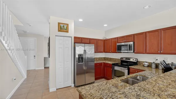 a kitchen with stainless steel appliances granite countertop a refrigerator sink and stove