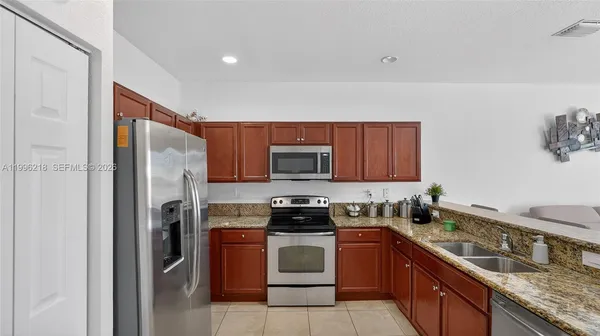 a kitchen with a refrigerator and a stove top oven