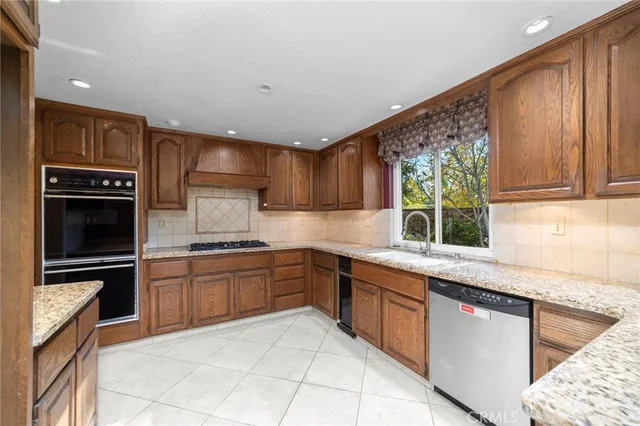 a kitchen with stainless steel appliances granite countertop a stove sink and cabinets