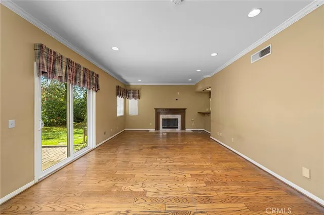 a view of an empty room with a fireplace and a window