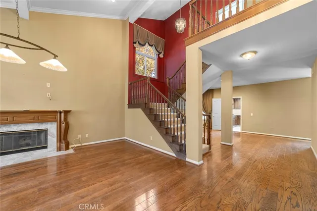 a view of an empty room with wooden floor and a fireplace