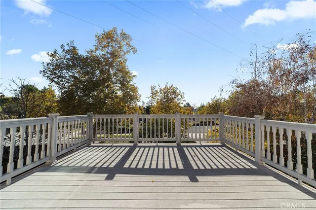 a view of balcony with wooden floor and fence