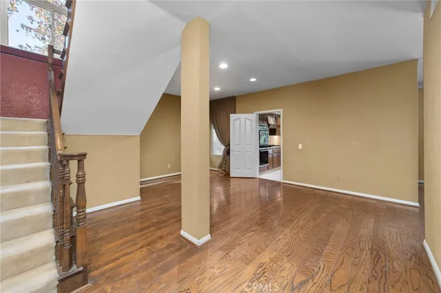 a view of a hallway with wooden floor and staircase