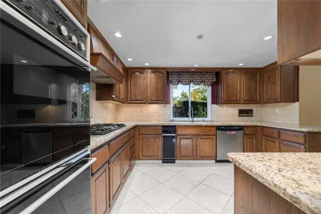 a kitchen with stainless steel appliances granite countertop a sink and stove top oven