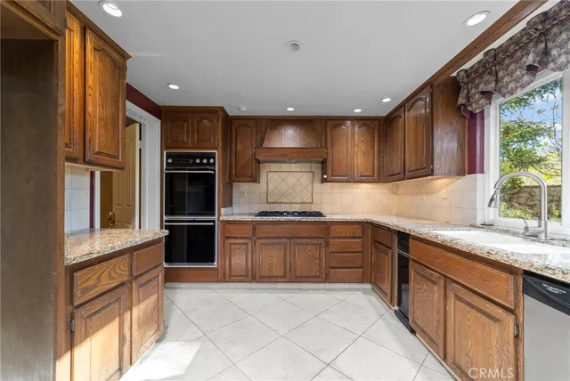 a kitchen with stainless steel appliances granite countertop a refrigerator sink and cabinets