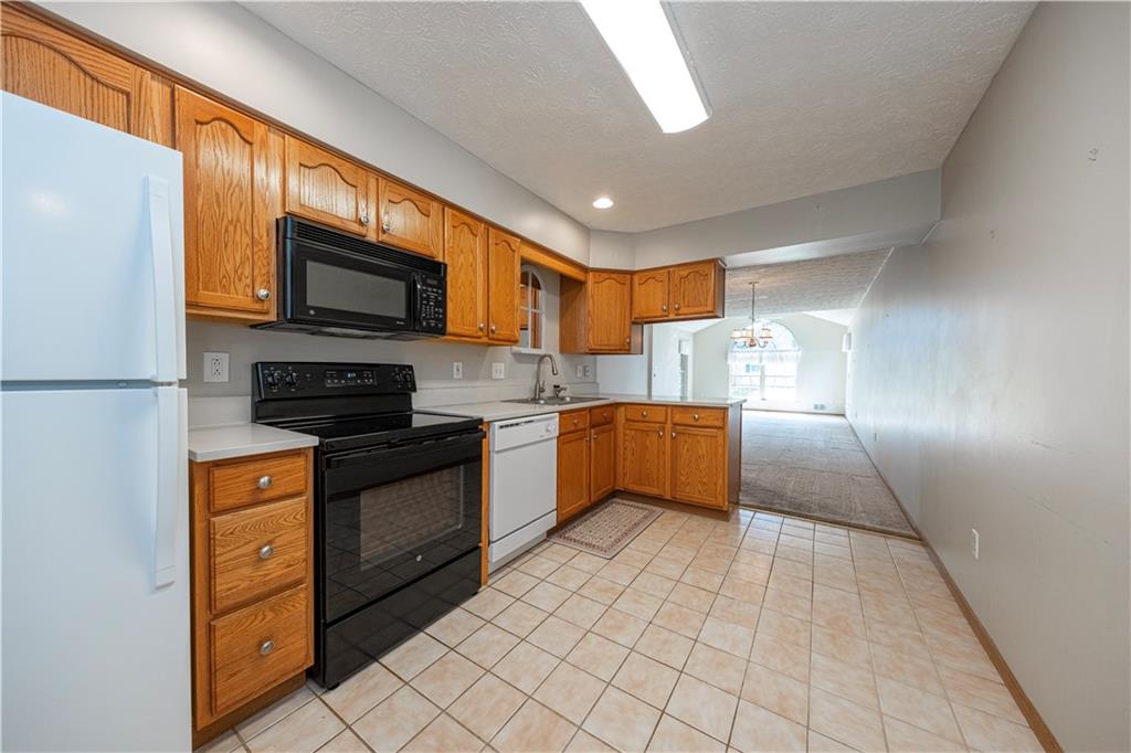 131 Pony Drive Freedom, PA 15042 - Photo 14 of 39 a kitchen with stainless steel appliances granite countertop a refrigerator a stove top oven a sink dishwasher and white cabinets with wooden floor