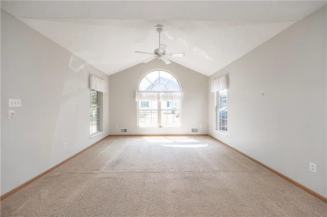 an empty room with windows and chandelier
