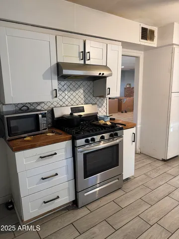 a kitchen with granite countertop a stove and a cabinets