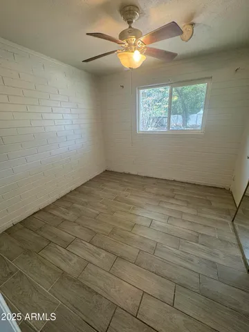 an empty room with windows and fan