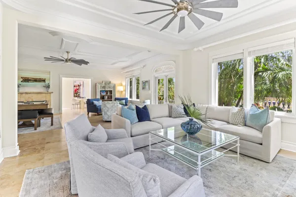 a living room with furniture a wooden floor and a ceiling fan