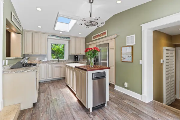 a kitchen with stainless steel appliances kitchen island granite countertop a stove and cabinets