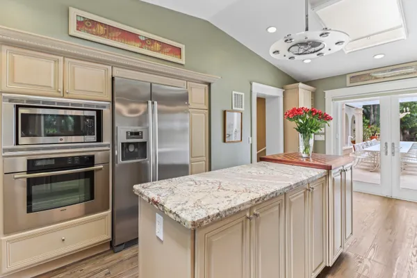 a view of a dining room with furniture one side kitchen view and wooden floor