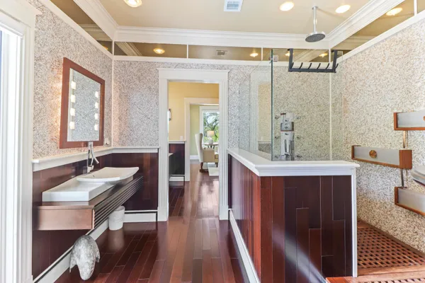 a bathroom with a granite countertop sink a mirror and a shower