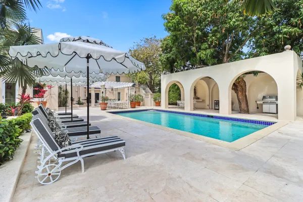 a view of a patio with table and chairs potted plants and floor to ceiling window and potted plants