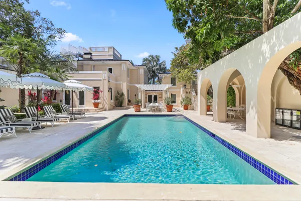 a front view of a house with a yard and fountain