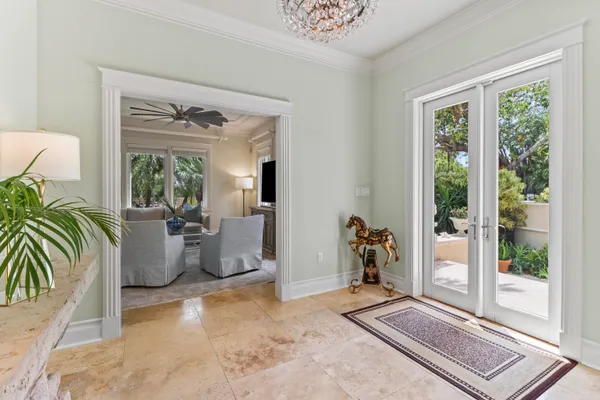 a living room with furniture a large window and a chandelier