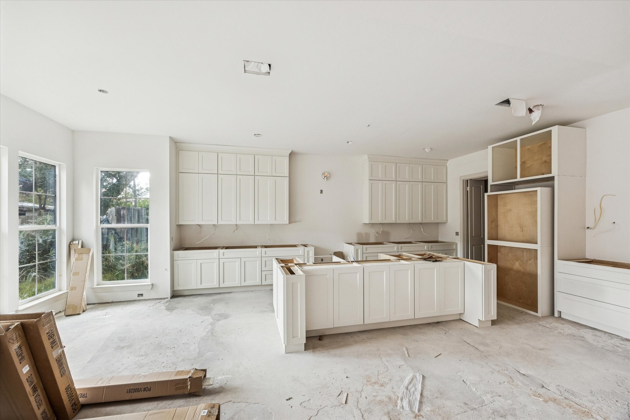 10303 Eddystone Drive Houston, TX 77043 - Photo 2 of 21 a large white kitchen with kitchen island a large window and stainless steel appliances