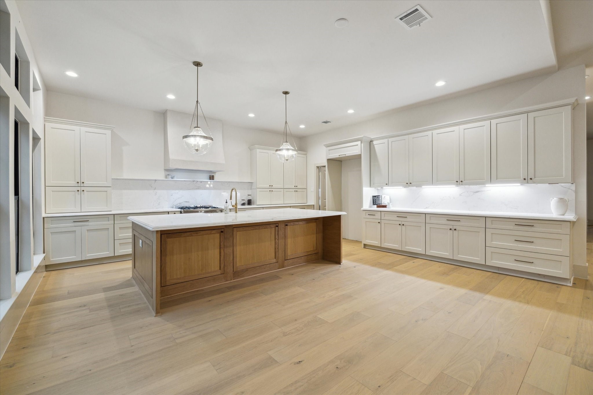 10303 Eddystone Drive Houston, TX 77043 - Photo 7 of 21 a large white kitchen with kitchen island a sink stainless steel appliances and cabinets