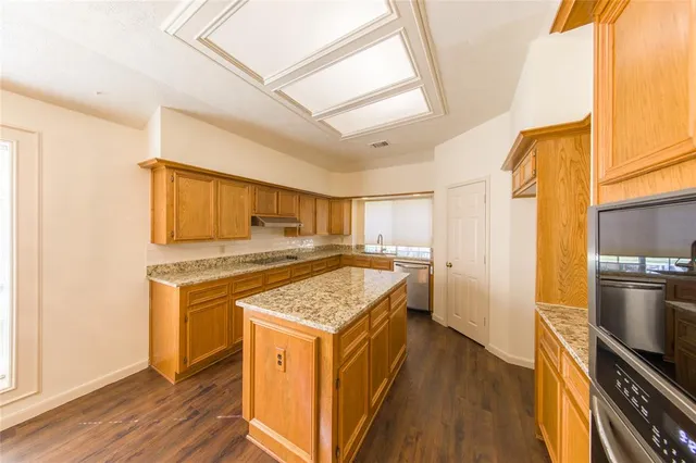 a kitchen with a stove a refrigerator and wooden floor
