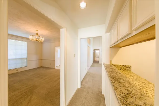 a view of a hallway with wooden floor and a bathroom