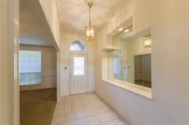 a view of a hallway with wooden floor and a chandelier