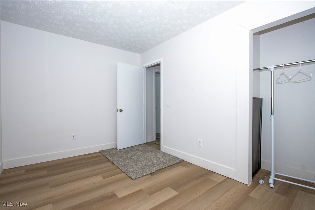 2781 North Firestone Road Wooster, OH 44691 - Photo 24 of 41 Unfurnished bedroom featuring a closet, hardwood / wood-style floors, and a textured ceiling