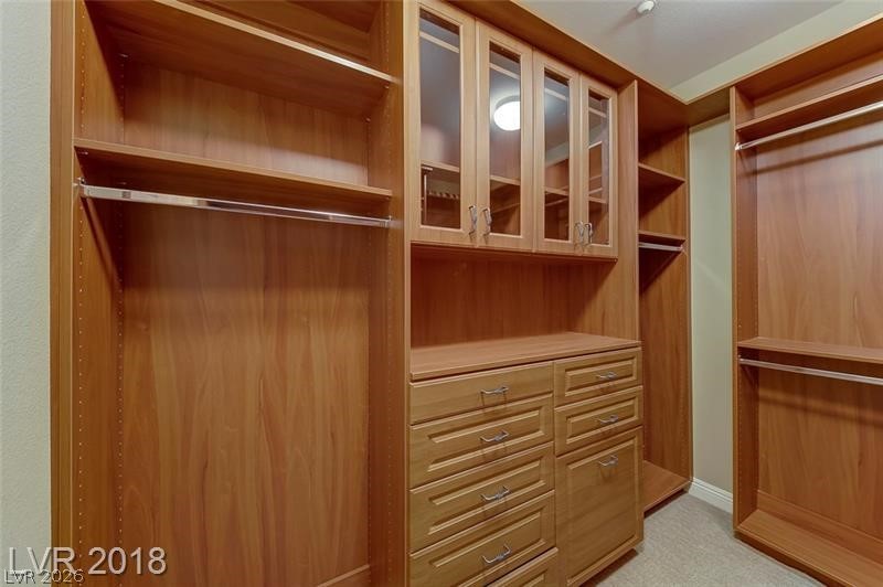 3144 Whitfeild Avenue Henderson, NV 89044 - Photo 25 of 55 Organized living with extensive custom cabinetry and hanging rods in this well-appointed closet space.