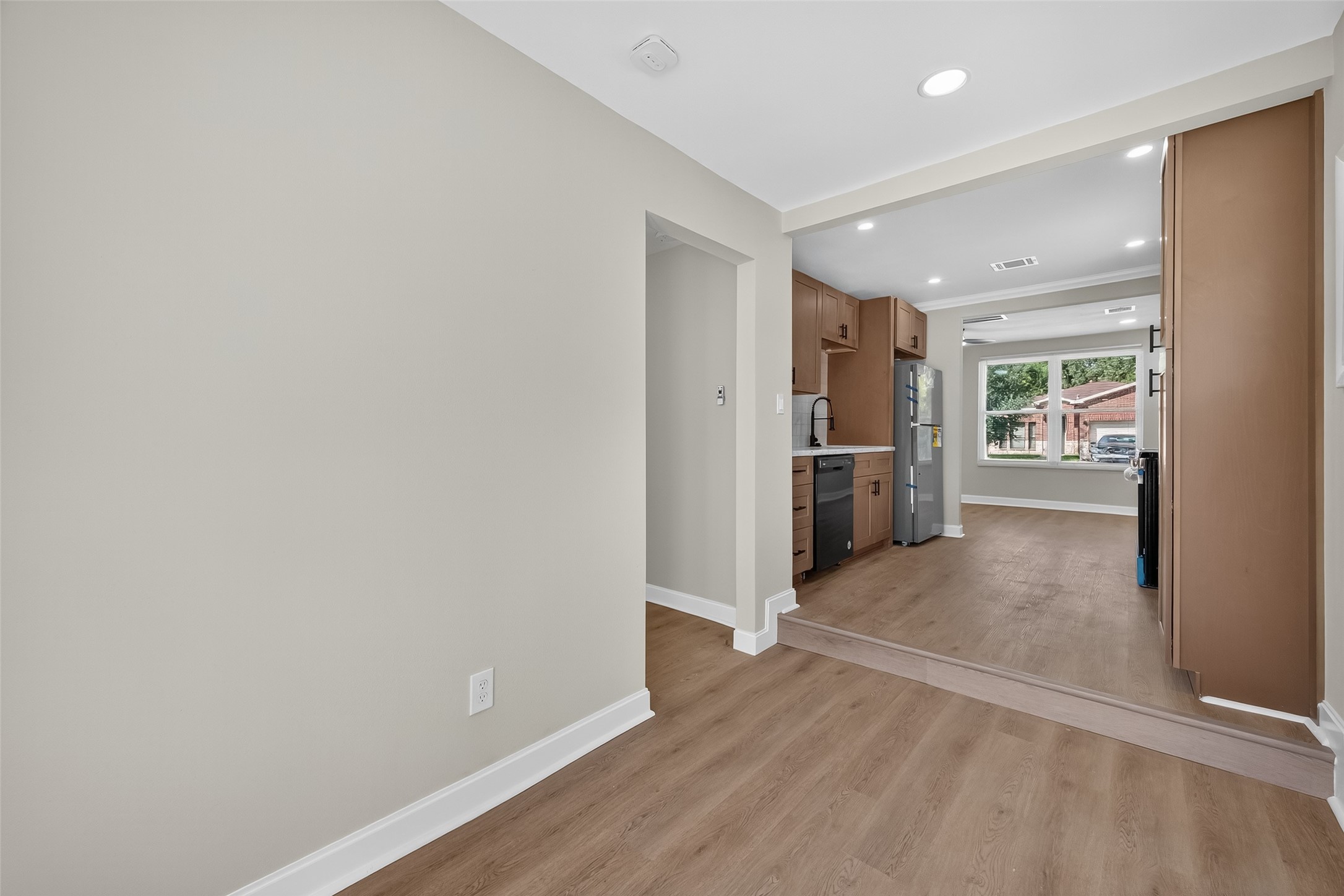 889 Chas Lane Houston, TX 77091 - Photo 14 of 32 a view of an empty room with wooden floor and kitchen