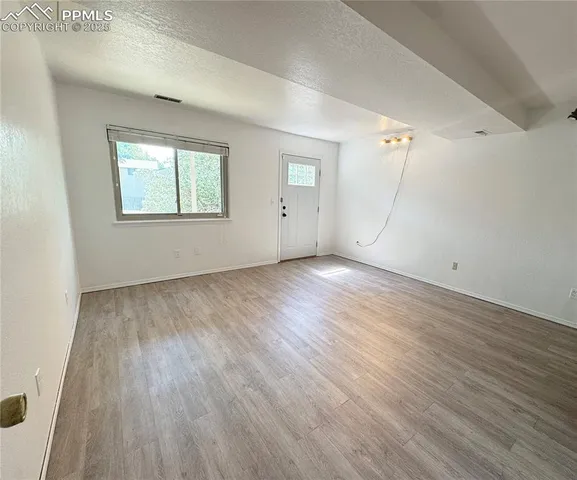 a view of empty room with wooden floor