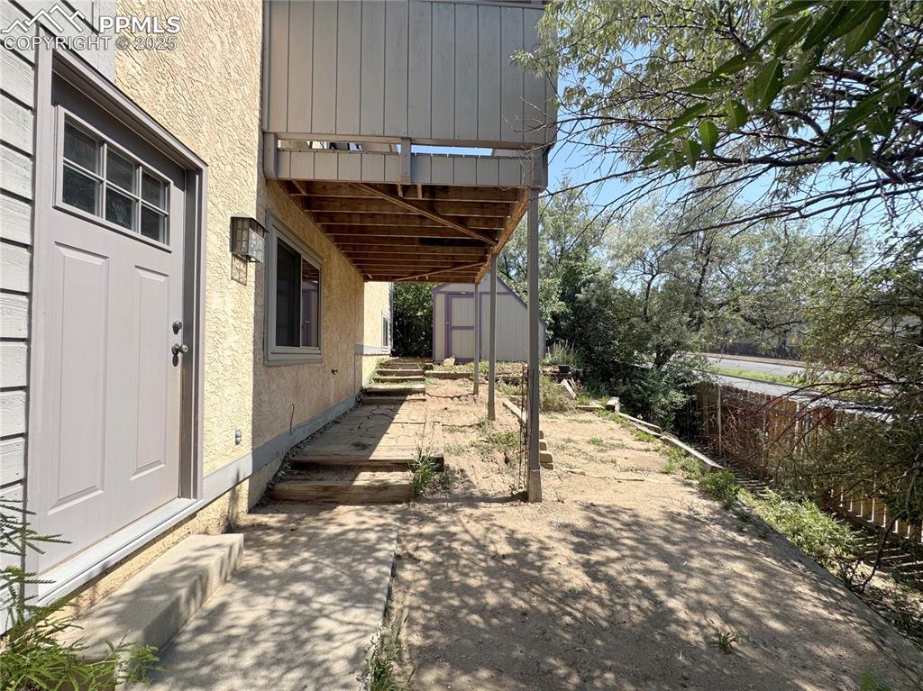 5117 Solar Ridge Drive Colorado Springs, CO 80917 - Photo 25 of 28 a view of a patio with table and chairs with wooden fence and plants