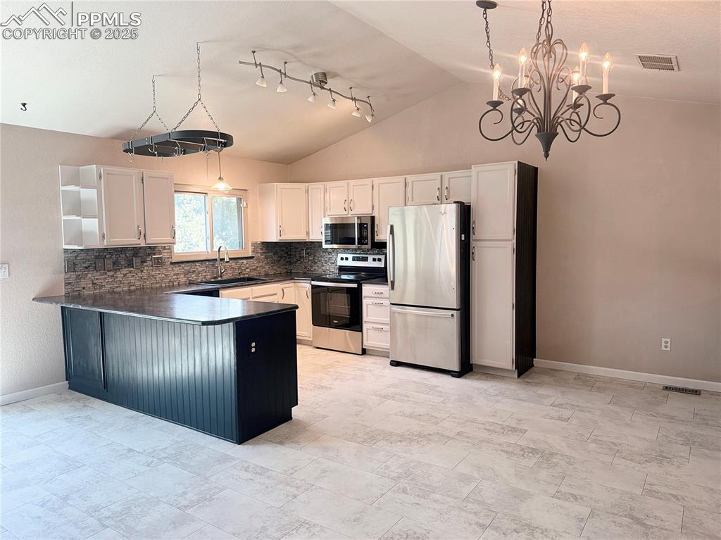 5117 Solar Ridge Drive Colorado Springs, CO 80917 - Photo 7 of 28 a kitchen with stainless steel appliances granite countertop a refrigerator a sink dishwasher a stove a refrigerator and a chandelier