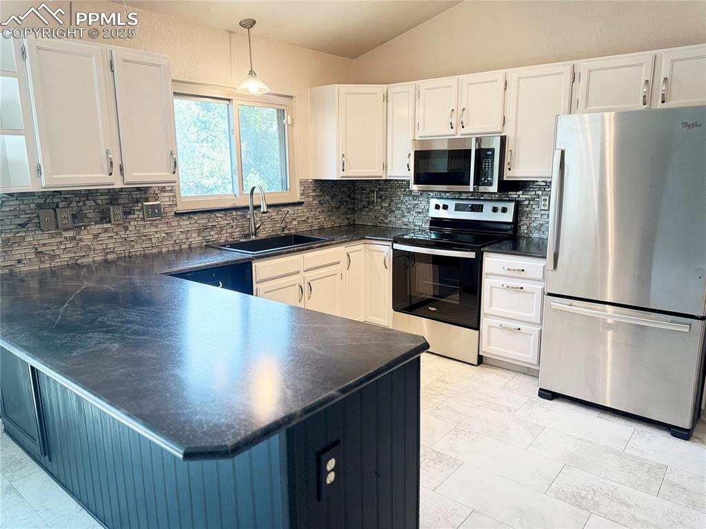 5117 Solar Ridge Drive Colorado Springs, CO 80917 - Photo 8 of 28 a kitchen with stainless steel appliances granite countertop a refrigerator a stove a microwave and a sink