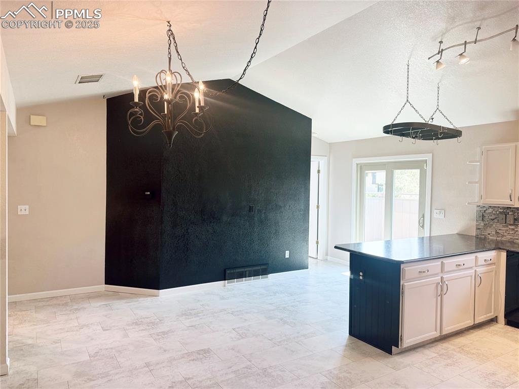 5117 Solar Ridge Drive Colorado Springs, CO 80917 - Photo 9 of 28 a dining room with a cabinet and a chandelier