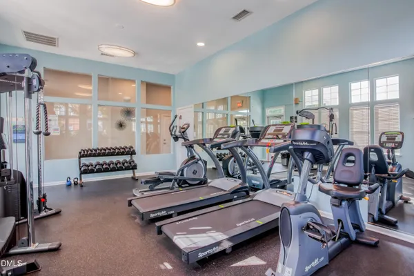 a room with gym equipment and large mirror
