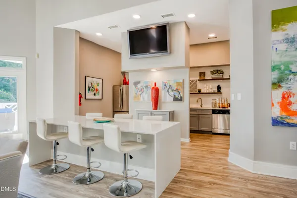 a living room with stainless steel appliances furniture and a kitchen view