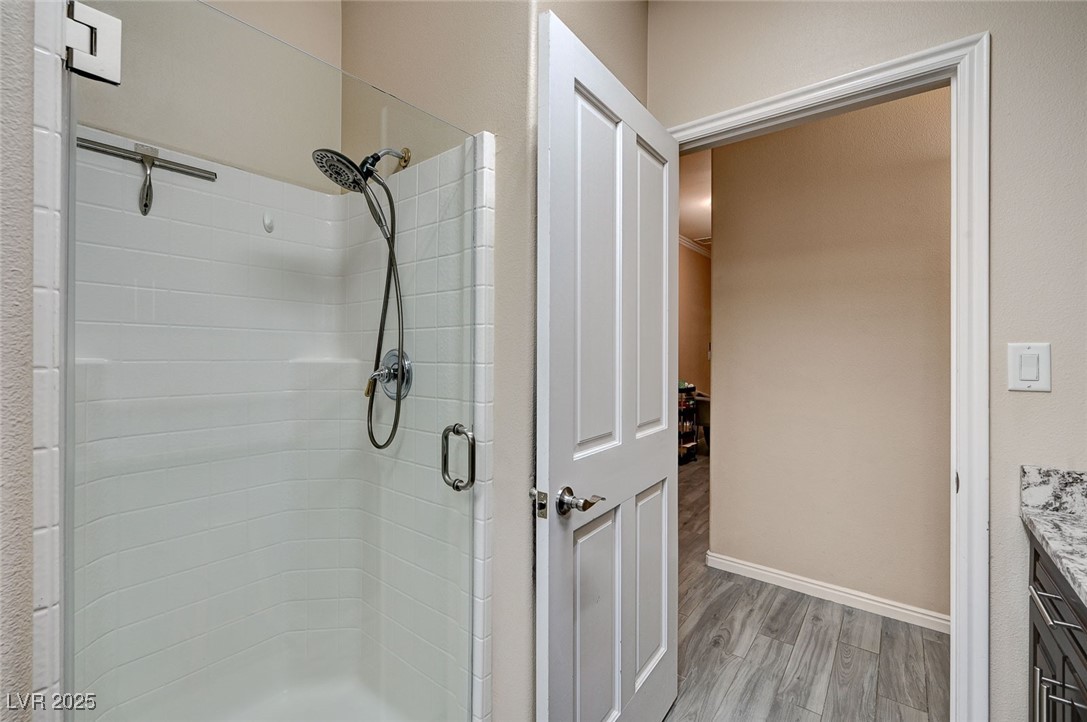 2125 Mateuse Street Logandale, NV 89021 - Photo 45 of 62 Full bath featuring vanity, a stall shower, baseboards, and wood finished floors