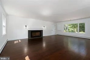 an empty room with wooden floor and a fireplace