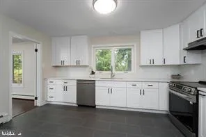 a kitchen with granite countertop white cabinets and white appliances